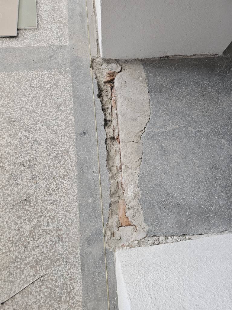 Poškodená terrazzo podlaha pred renováciou na Gymnáziu Alberta Einsteina