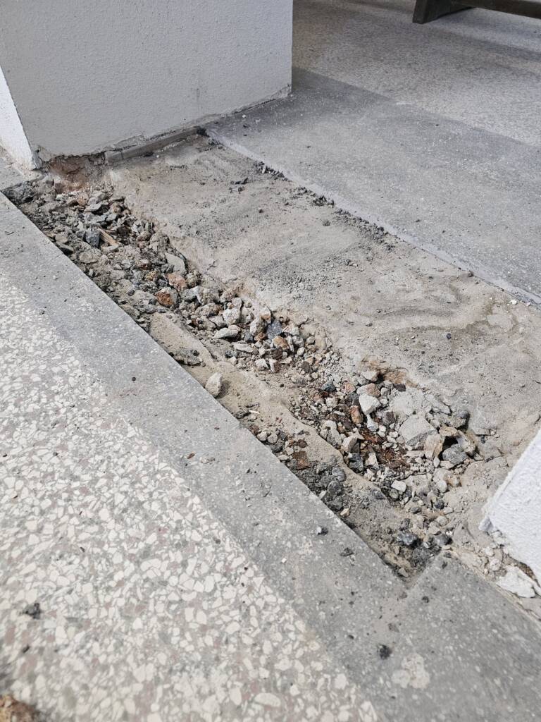 Poškodená terrazzo podlaha pred renováciou na Gymnáziu Alberta Einsteina