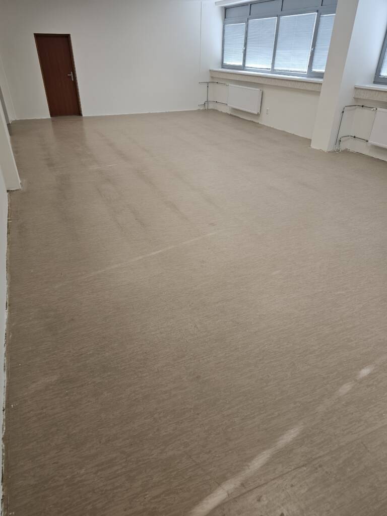 Učebňa pred farebným lakovaním podlahy, zanesená béžová PVC.